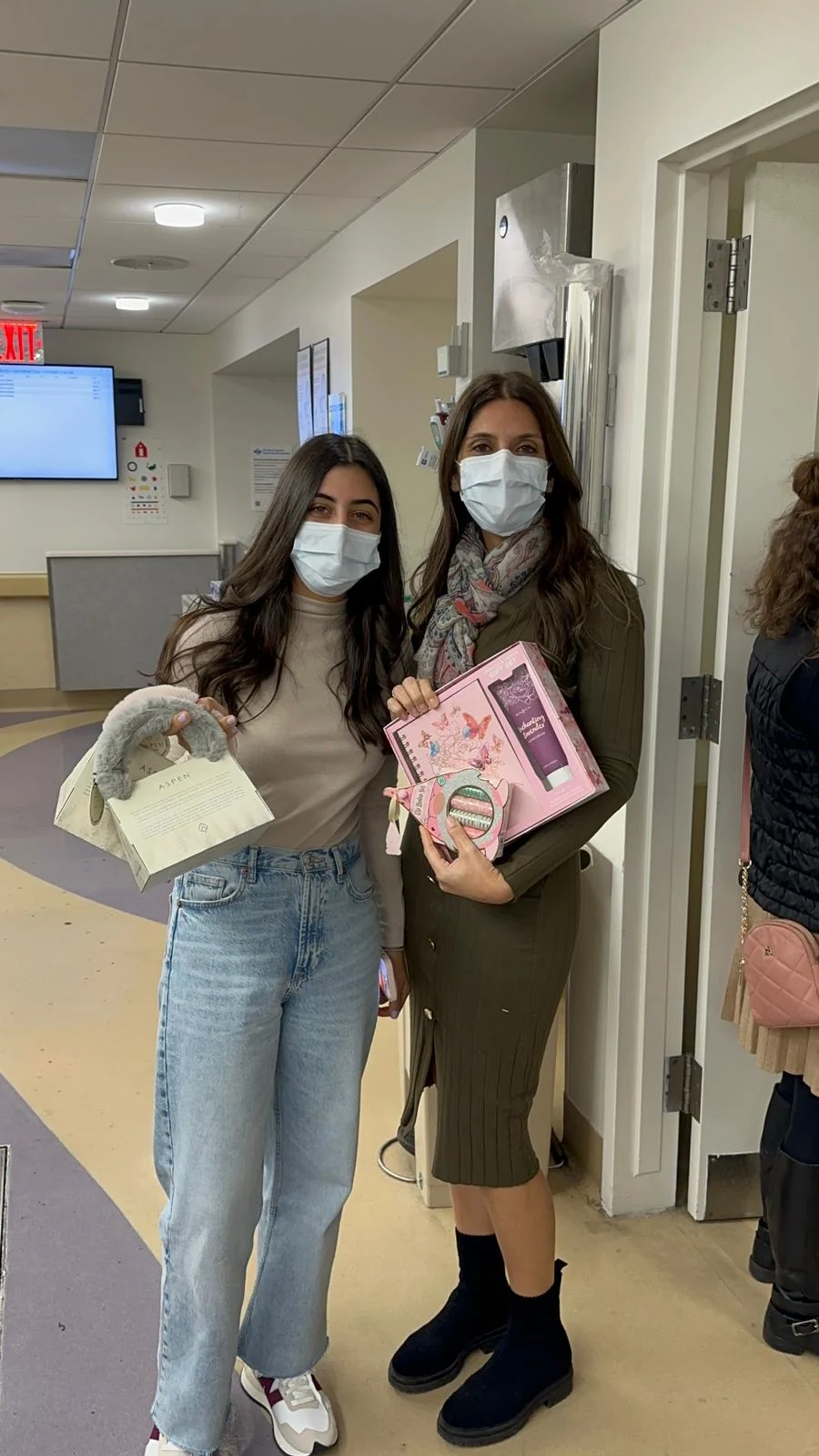Volunteers carrying toys through a hospital corridor
