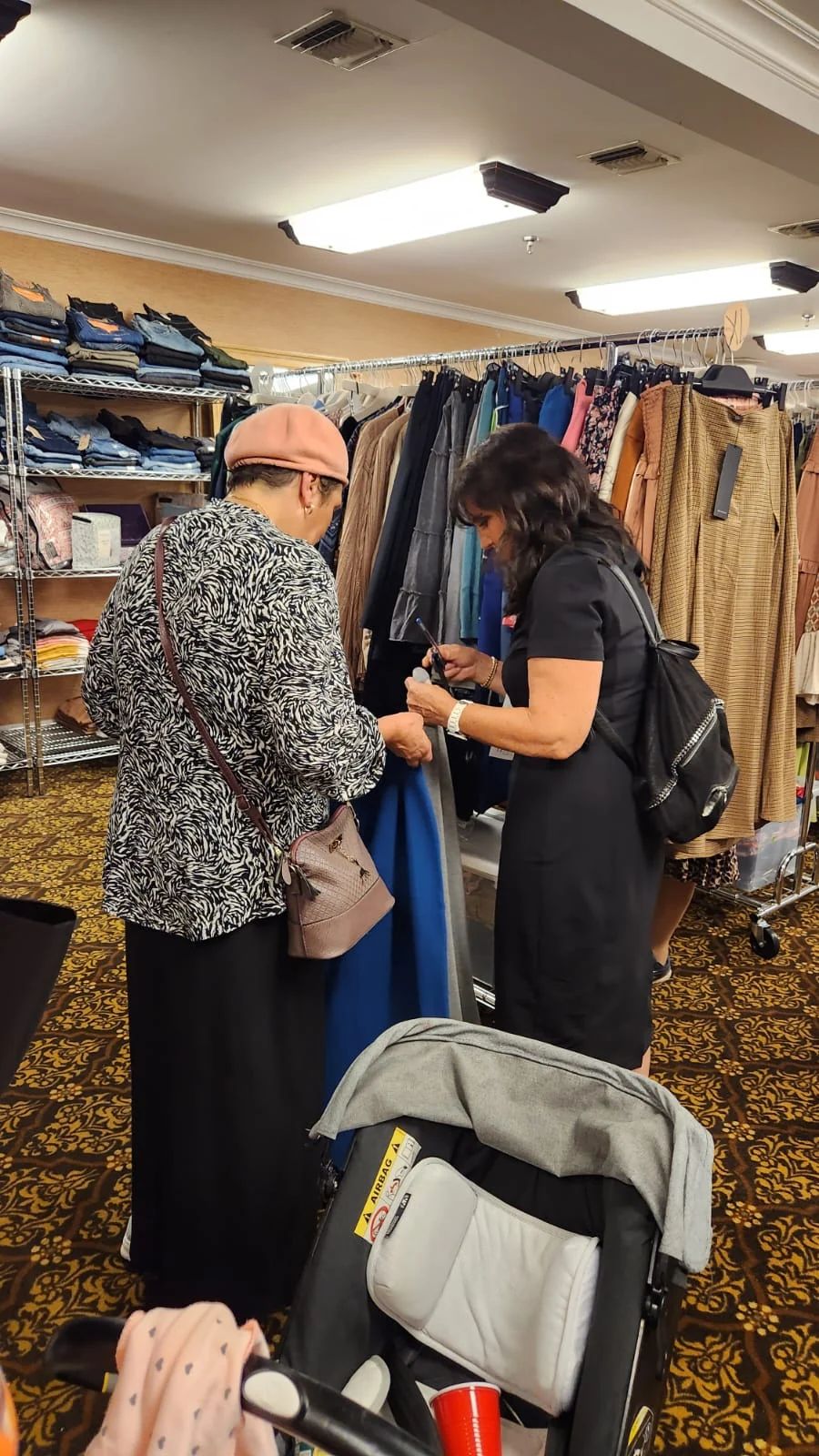 A conversation beside clothing rails